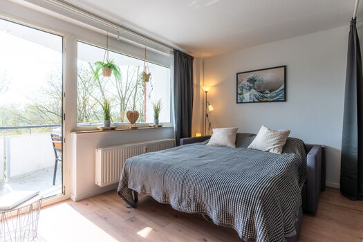 Wohnzimmer mit Schlafcouch (160 x 200cm) für 2 Personen; Smart-TV (mit Netflix-App), geschmackvoller Dekoration und Zugang zum Balkon Wohnzimmer mit Schlafcouch (160 x 200cm) für 2 Personen; Smart-TV (mit Netflix-App), geschmackvoller Dekoration und Zugang zum Balkon