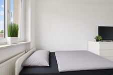 Schlafzimmer mit komfortablen Einzelbetten und Smart-TV für entspannte Abende. Schlafzimmer mit komfortablen Einzelbetten und Smart-TV für entspannte Abende.