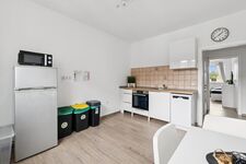 Voll ausgestattete Küche mit Spülmaschine, großem Kühlschrank und gemütlichem Sitzbereich. Voll ausgestattete Küche mit Spülmaschine, großem Kühlschrank und gemütlichem Sitzbereich.
