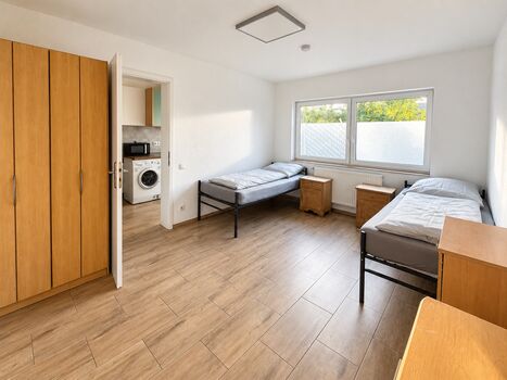 Helles Zimmer mit getrennten Betten, Schrank und Zugang zur Küche Helles Zimmer mit getrennten Betten, Schrank und Zugang zur Küche