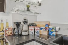 Küchenzeile mit Kaffeemaschine, Mixer, Kaffeepads und verschiedenen Frühstückszutaten. Küchenzeile mit Kaffeemaschine, Mixer, Kaffeepads und verschiedenen Frühstückszutaten.
