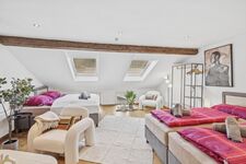 Weitläufiges Dachzimmer mit sichtbarem Holzbalken, vier Betten mit pinker Bettwäsche, zwei Dachfenst Weitläufiges Dachzimmer mit sichtbarem Holzbalken, vier Betten mit pinker Bettwäsche, zwei Dachfenst