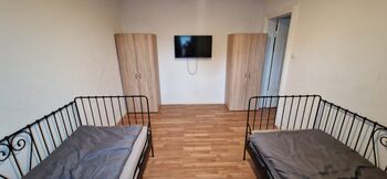 Einzelzimmer mit zwei Betten, TV und Kleiderschrank Einzelzimmer mit zwei Betten, TV und Kleiderschrank