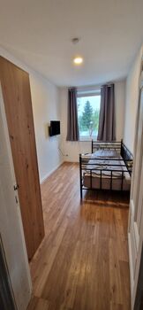 Einzelzimmer mit einem Bett, TV und Kleiderschrank Einzelzimmer mit einem Bett, TV und Kleiderschrank