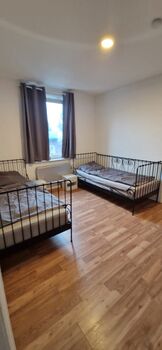 Einzelzimmer mit einem Bett, TV und Kleiderschrank Einzelzimmer mit einem Bett, TV und Kleiderschrank