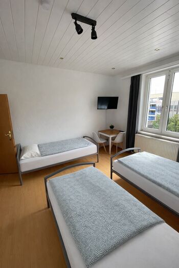 helles Zimmer mit 3 Einzelbetten, Ferseher und Tisch helles Zimmer mit 3 Einzelbetten, Ferseher und Tisch