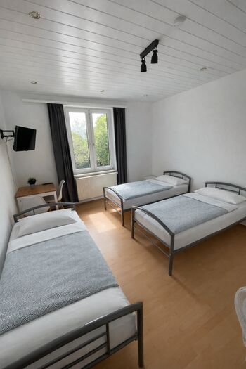 helles Zimmer mit 3 Einzelbetten, Ferseher und Tisch helles Zimmer mit 3 Einzelbetten, Ferseher und Tisch