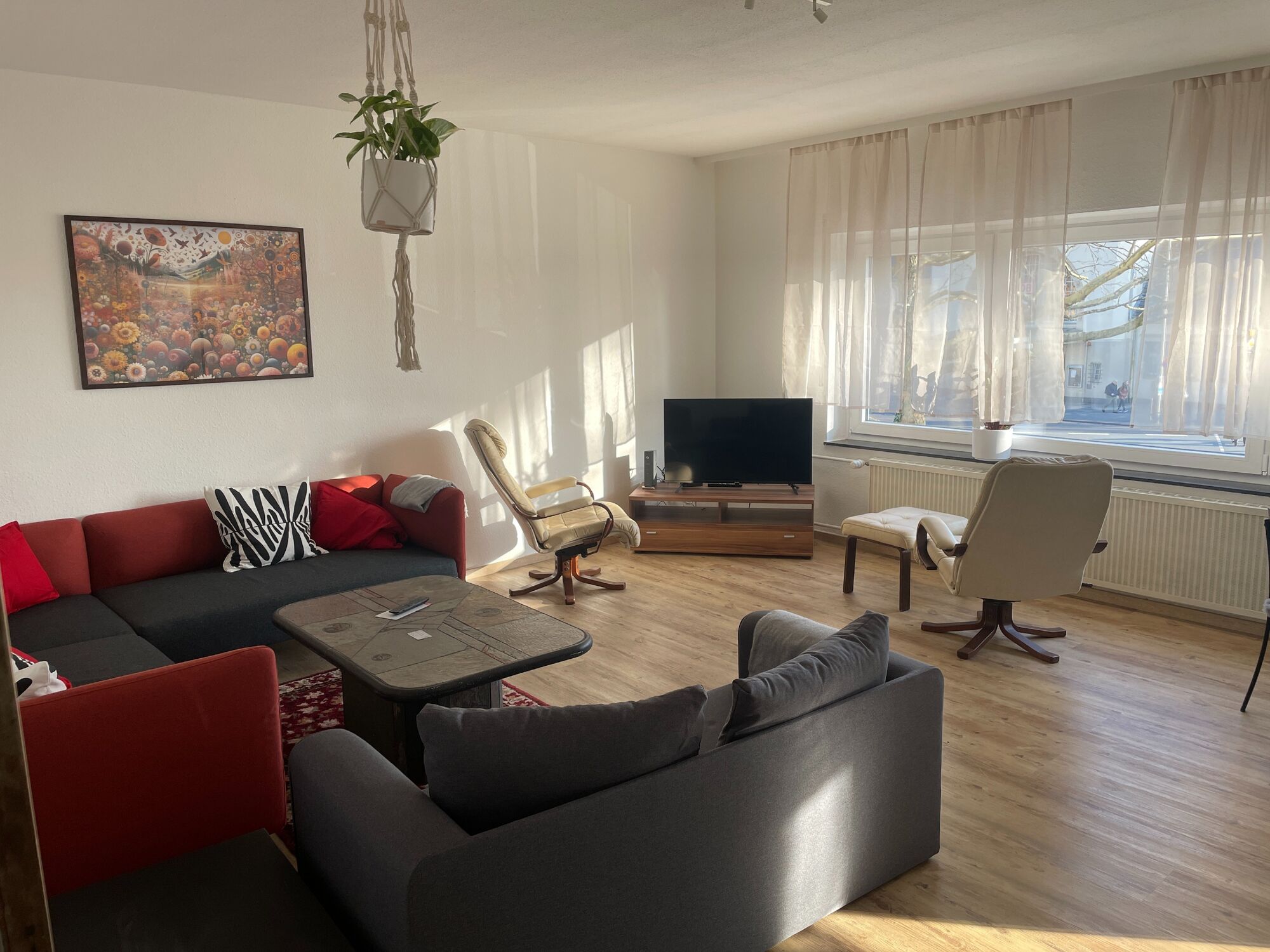 Geräumiges Wohnzimmer mit großer Couch, Esstisch und viel Tageslicht – ideal für entspannte Abende Geräumiges Wohnzimmer mit großer Couch, Esstisch und viel Tageslicht – ideal für entspannte Abende