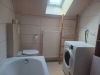 Badezimmer mit Toilette und Waschtrockner Badezimmer mit Toilette und Waschtrockner