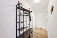 Heller Flur mit moderner Garderobe aus Holz und Metall, dekorativen Akzenten und stilvoller Wandgestaltung. Heller Flur mit moderner Garderobe aus Holz und Metall, dekorativen Akzenten und stilvoller Wandgestaltung.