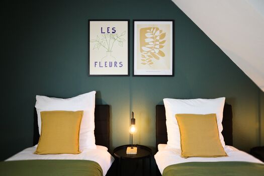 Schlafzimmer 1 - Twin-Schlafzimmer mit zwei Einzelbetten, hochwertiger Bettwäsche, TV, Nachttischlampen und ruhigen Grüntönen. Schlafzimmer 1 - Twin-Schlafzimmer mit zwei Einzelbetten, hochwertiger Bettwäsche, TV, Nachttischlampen und ruhigen Grüntönen.