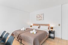 Wohnzimmer mit zwei hochwertigen Boxspringbetten und einem gemütlichen Essbereich. Die Betten können wahlweise einzeln oder als komfortables Doppelbett gestellt werden. Wohnzimmer mit zwei hochwertigen Boxspringbetten und einem gemütlichen Essbereich. Die Betten können wahlweise einzeln oder als komfortables Doppelbett gestellt werden.