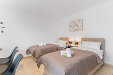 Wohnzimmer mit zwei hochwertigen Boxspringbetten und einem gemütlichen Essbereich. Die Betten können wahlweise einzeln oder als komfortables Doppelbett gestellt werden. Wohnzimmer mit zwei hochwertigen Boxspringbetten und einem gemütlichen Essbereich. Die Betten können wahlweise einzeln oder als komfortables Doppelbett gestellt werden.