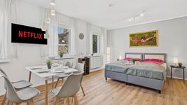 Offener Grundriss mit Bett, Esstisch, Küche und Fenster mit Blick ins Grüne. Offener Grundriss mit Bett, Esstisch, Küche und Fenster mit Blick ins Grüne.