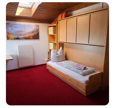 Ein Einzelbett, das bei Bedarf oben ausziehbar ist und dann als Stockbett genutzt werden kann.