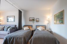 Schlafzimmer 2 mit zwei getrennten Betten (optional), Stehlampe, Leselampe und privaten Steckdosen