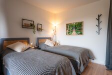 Schlafzimmer 2 mit zwei getrennten Betten (optional), Stehlampe, Leselampe und privaten Steckdosen