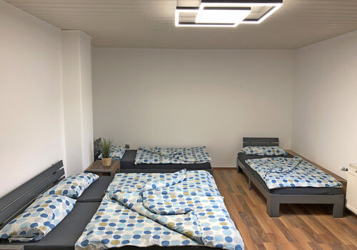 großes Schlafzimmer mit 1 Doppelbett und 2 Einzelbetten