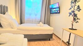 Schlafzimmer mit Smart-TV und Hotelbetten