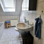 Privates Badezimmer der Dachgeschosswohnung mit Badewanne, Dusche, WC und Handtüchern.