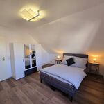 Geräumiges Schlafzimmer der Dachgeschosswohnung mit Doppelbett, Arbeitsplatz, Kleiderschrank und viel Platz.