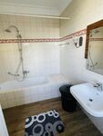 Geräumiges Badezimmer mit Badewanne und Waschbecken 