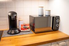 Voll ausgestattete Küche mit Mikrowelle und Kaffeemaschine