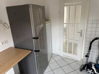 Küche mit Kühlschrank und weiteren Utensilien