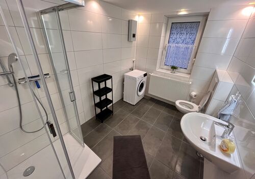 Frisch saniertes Wohlfühlbad mit eigener Waschmaschine – Sauberkeit und Komfort für Ihr Team, wie zu Hause