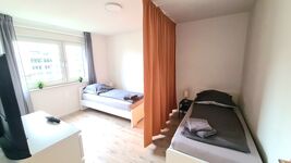 Schlafzimmer mit Einzelbetten und Vorhängen für Privatsphäre