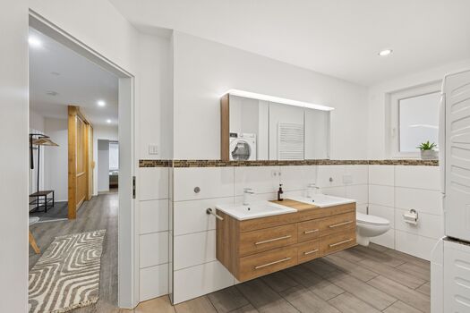 Bad mit Doppelwaschbereich und Blick in den Flur