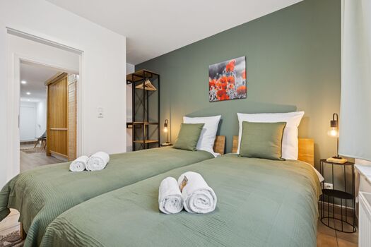 2-Bettzimmer mit Sitzbereich, als Einzel- oder Doppelbett möglich und Blick in den Flur