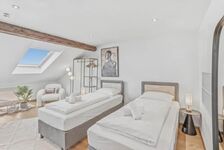 Helles Dachzimmer mit Dachflächenfenster, Einzelbett mit pinker Bettwäsche und Vintage-Regal.