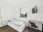 Blick auf ein Einzelbett mit Fernseher und Tisch
