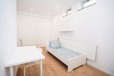 Schlafzimmer mit Einzelbett und Tisch