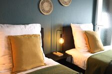 Schlafzimmer 3 - Twin-Schlafzimmer mit zwei Einzelbetten, hochwertiger Bettwäsche, TV, Nachttischlampen und ruhigen Grüntönen.