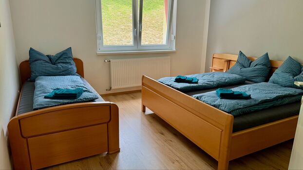 Großes Schlafzimmer mit Doppelbett und Einzelbett