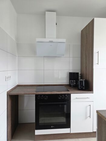 Küche mit Herd, Backofen, Kühlschrank und allem was dazu gehört