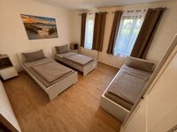 Großes Schlafzimmer mit drei Betten und Kleiderschrank