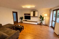 Wohnzimmer mit Flachbildschirm TV und Sofa mit Schlaffunktion