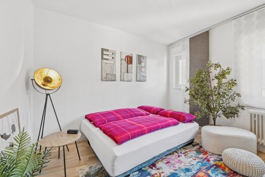 Helles Schlafzimmer mit Doppelbett & buntem Teppich – ankommen und durchatmen in Saarburg