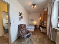 Kleines Schlafzimmer mit einem Einzelbett und Arbeitsbereich, Sessel