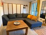 Wohnzimmer mit Einzelbett hinter der Trennwand
